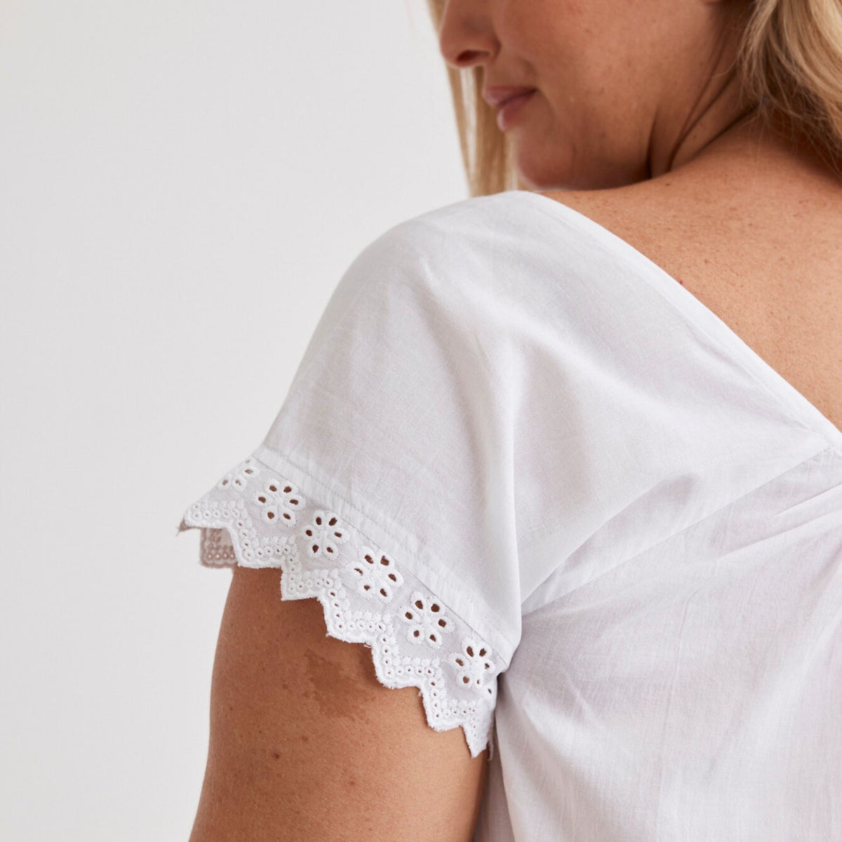Actual product photograph of white cotton sleepwear with broderie sleeve detailing
