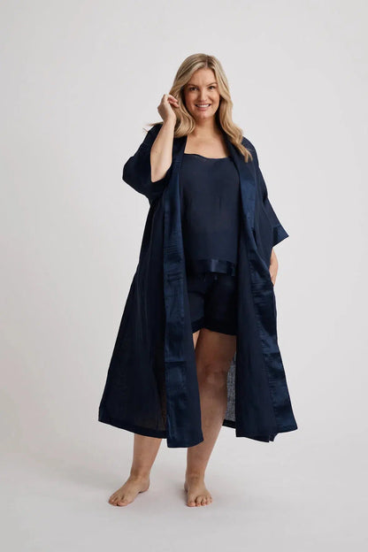 Woman wearing long Anne linen robe in navy, lightweight cover-up inclusive sizes XS–4XL, finished in Japanese satin